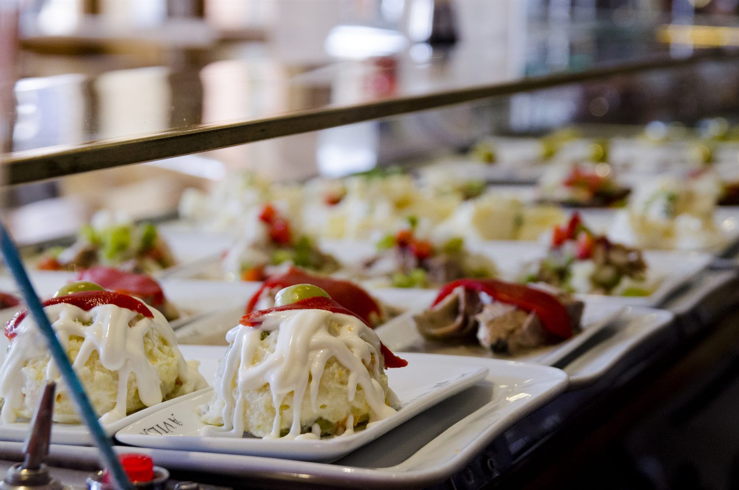 Surtido de pinchos de La Santa en la barra, con ensaladilla coronada de pimiento del piquillo